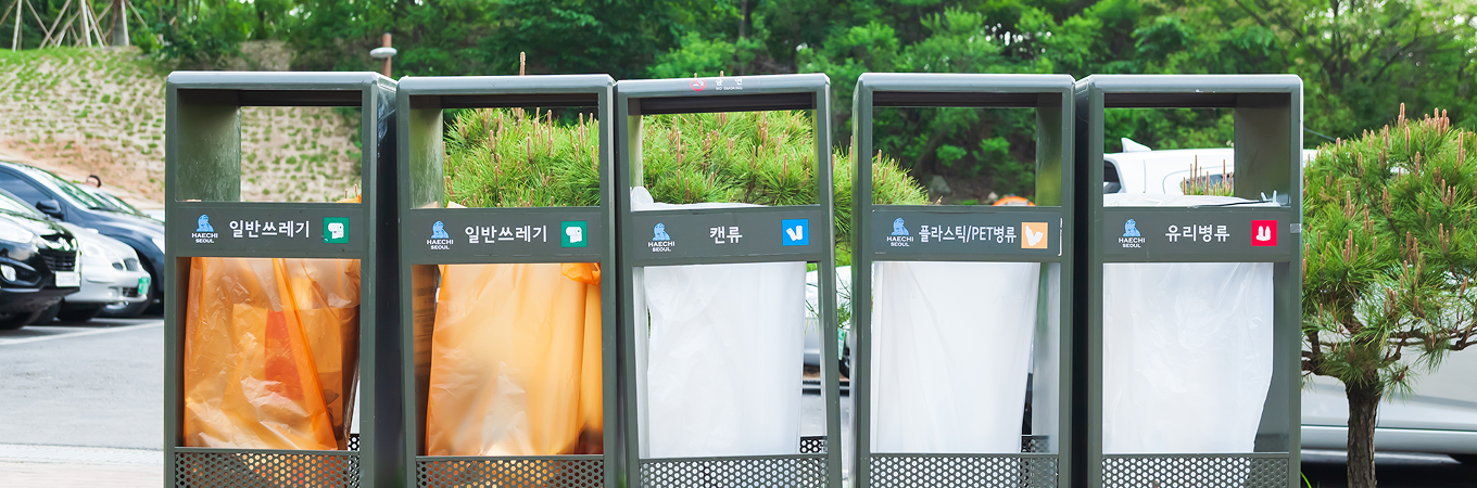 일반쓰레기, 캔류, 플라스틱(PET)병류, 유리병류 분리수거함이 나란히 설치된 모습